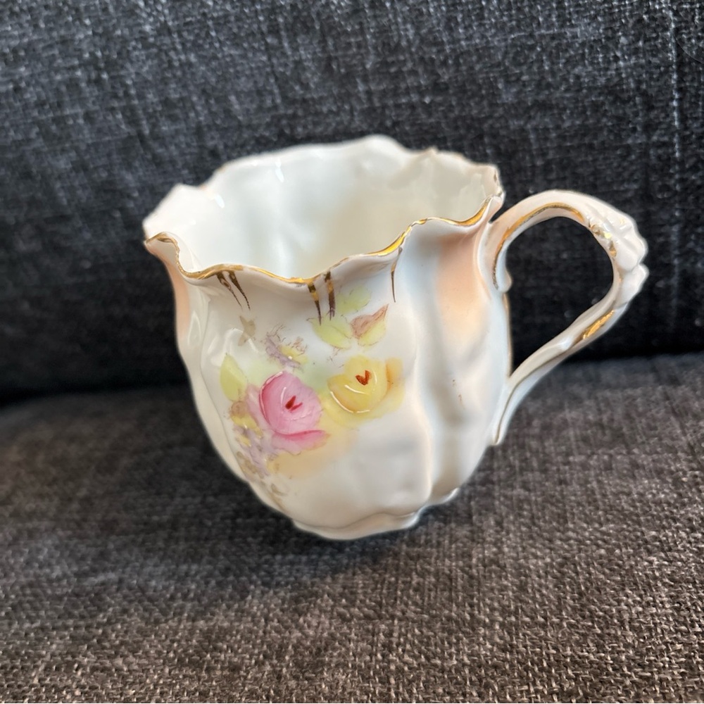 Vintage Creamer .  Pink and yellow floral print with gold tone trim. Approx 3”